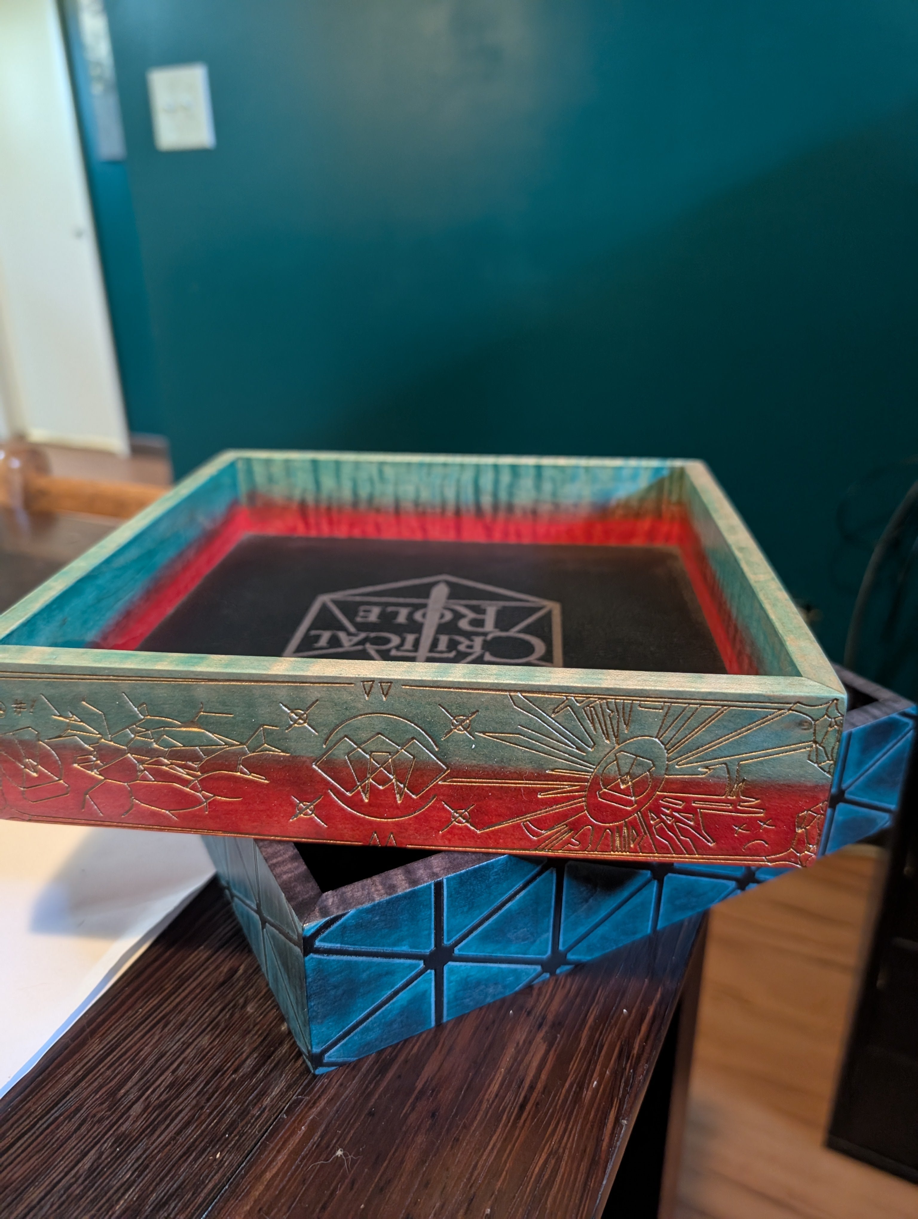 Decorative box with intricate designs on a wooden surface for Critical Role and Dimension 20
